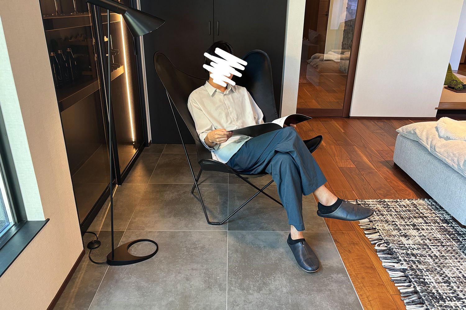 男性がチェアに座って本を読んでいる